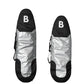 Two b surfboard carrying bags shown upright on a white background, each with a black top section featuring a white letter B, a reflective silver center, and black lower sections.