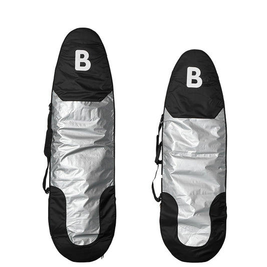 Two b surfboard carrying bags shown upright on a white background, each with a black top section featuring a white letter B, a reflective silver center, and black lower sections.